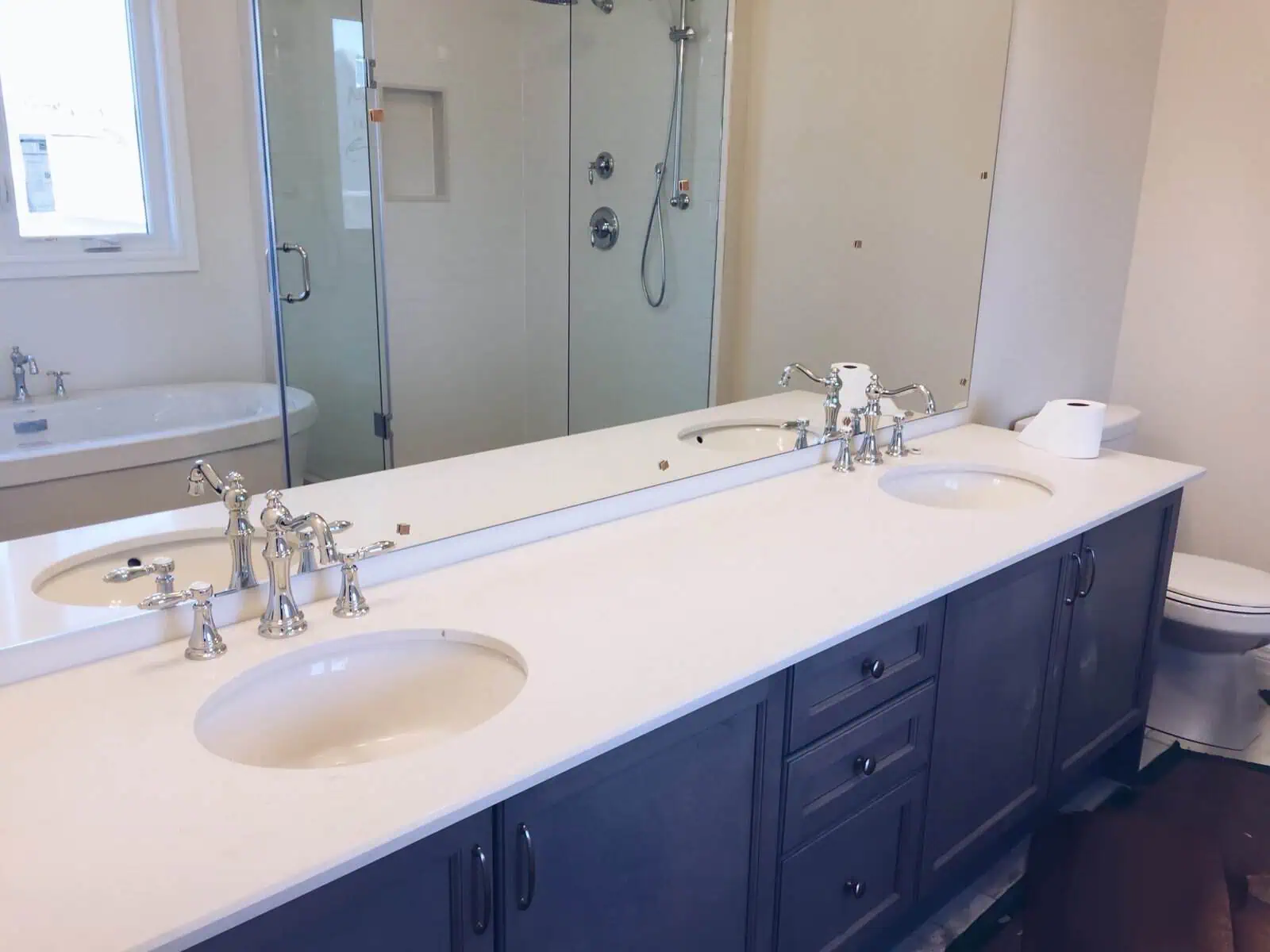 Contemporary bathroom with double sinks, large mirror, and walk-in shower.