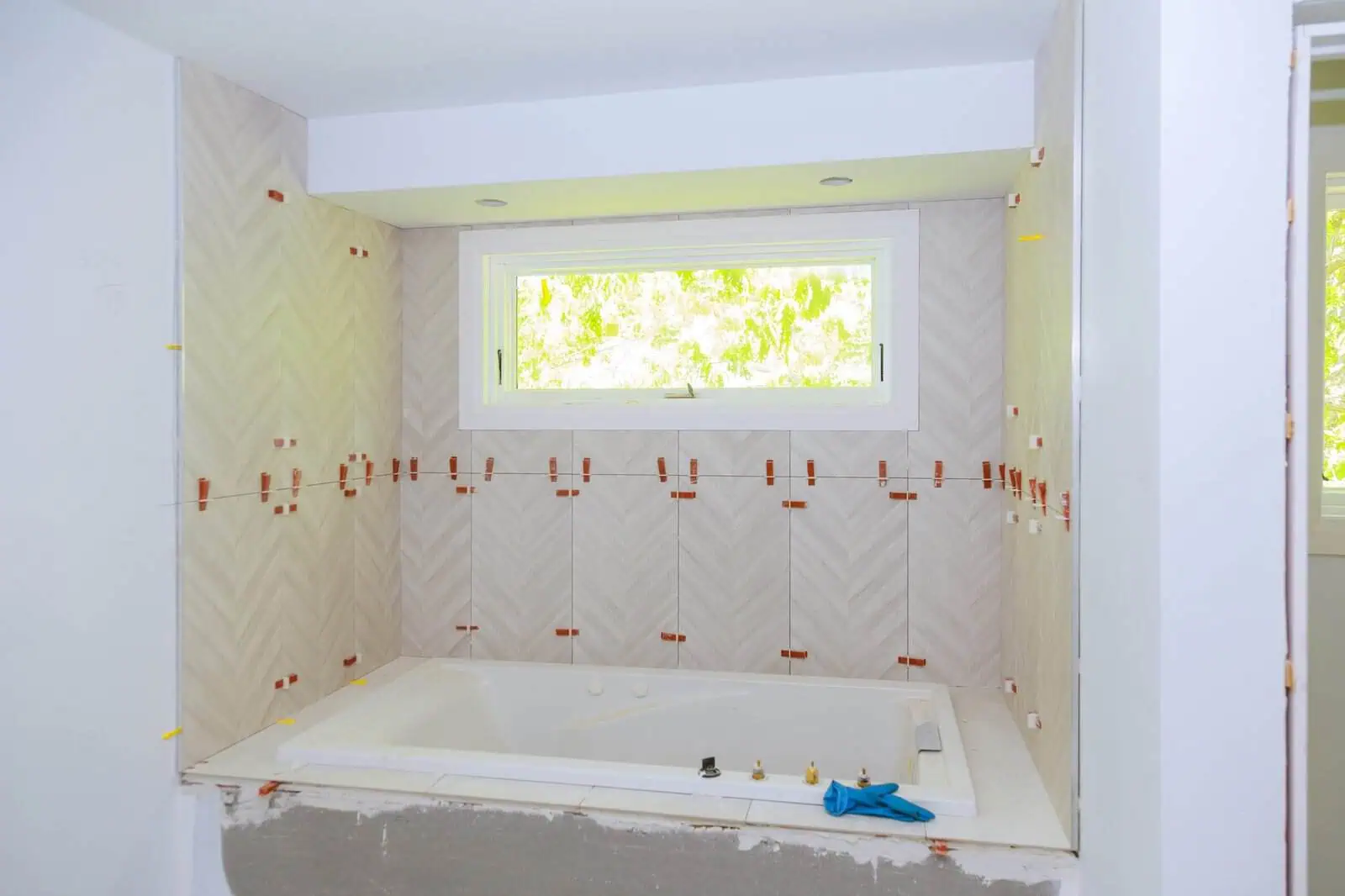 Bathroom renovation in progress with bathtub and window view.