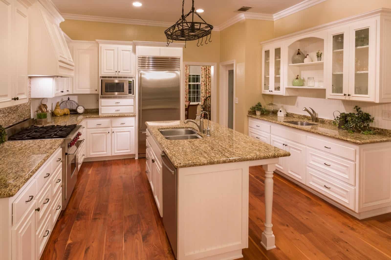Spacious kitchen with white cabinets and granite countertops.